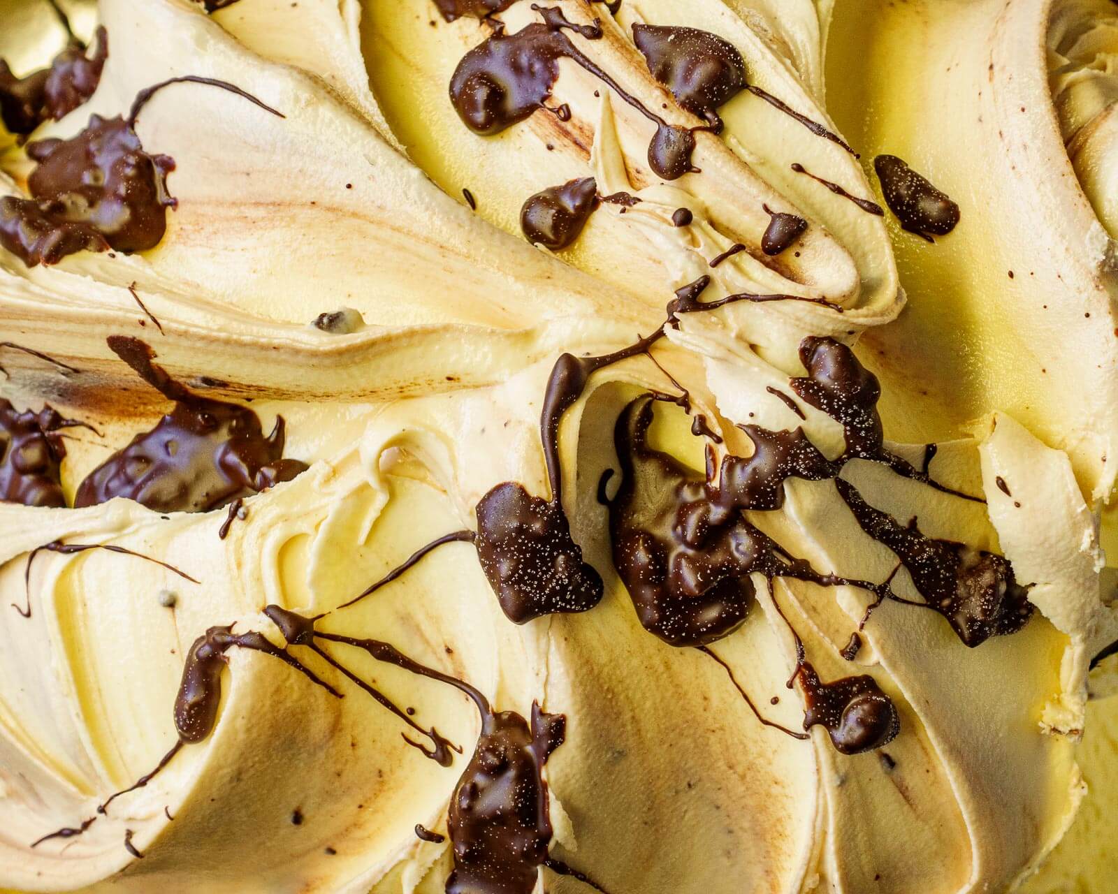 a close up of a dessert with bananas and chocolate